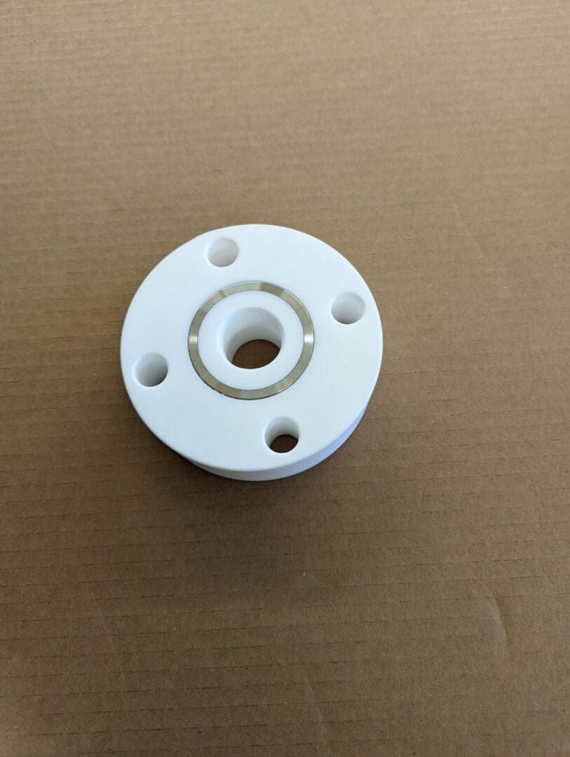 A white plastic pipe with four holes on it.