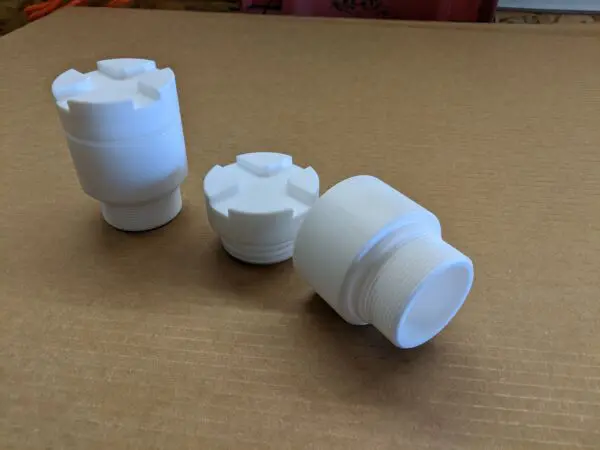 A group of three white plastic cups sitting on top of a table.