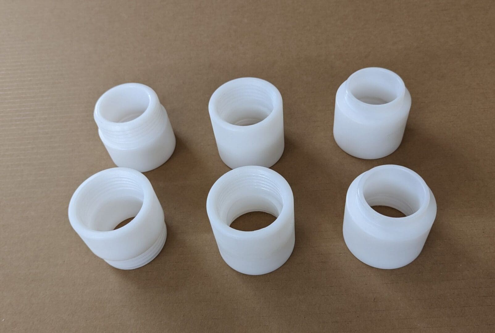 A group of six white plastic cups sitting on top of a table.