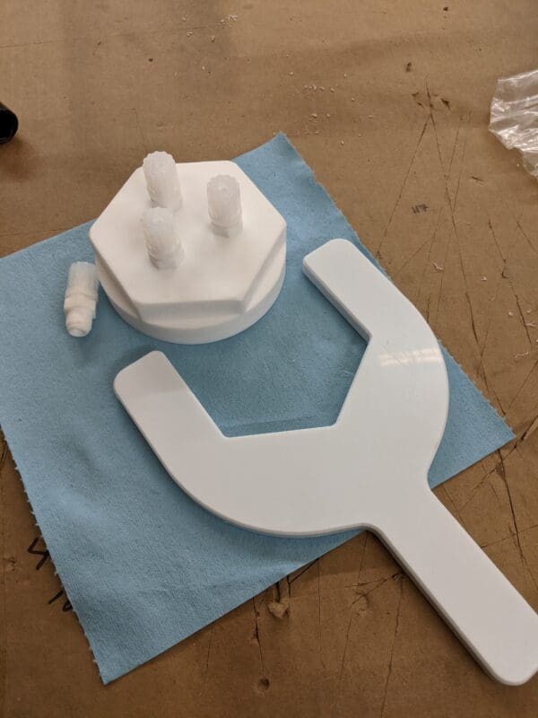 A white wrench and plug sitting on top of a blue paper.