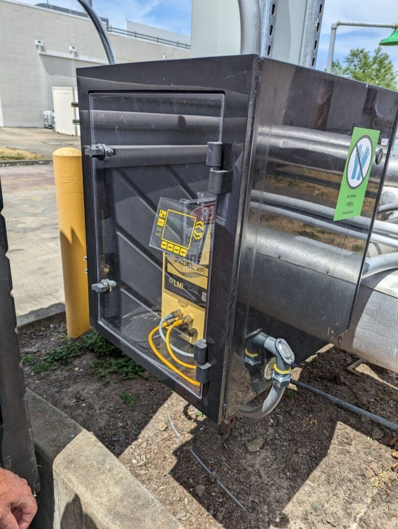 A black and yellow container with a hose attached to it.