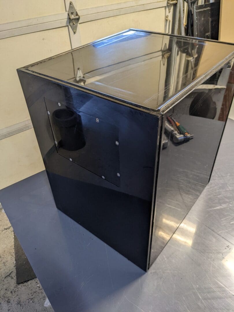 A black box with a glass top on the floor.