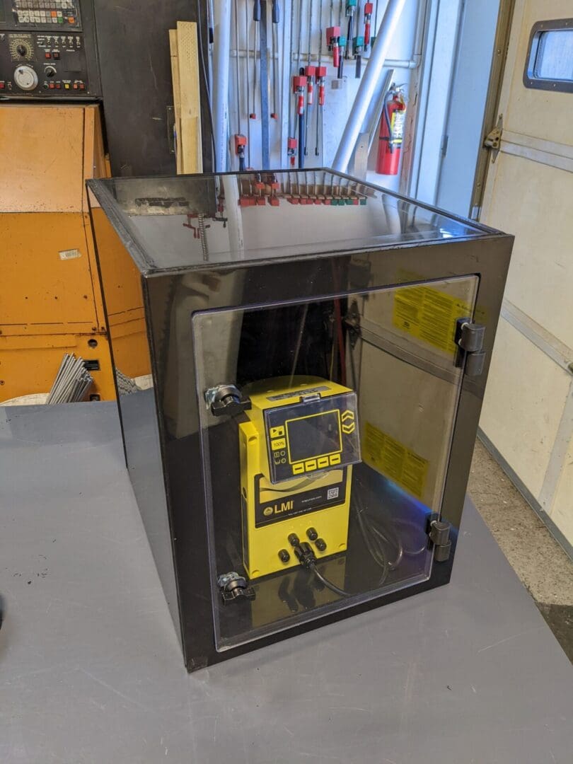 A yellow and black device in a glass case