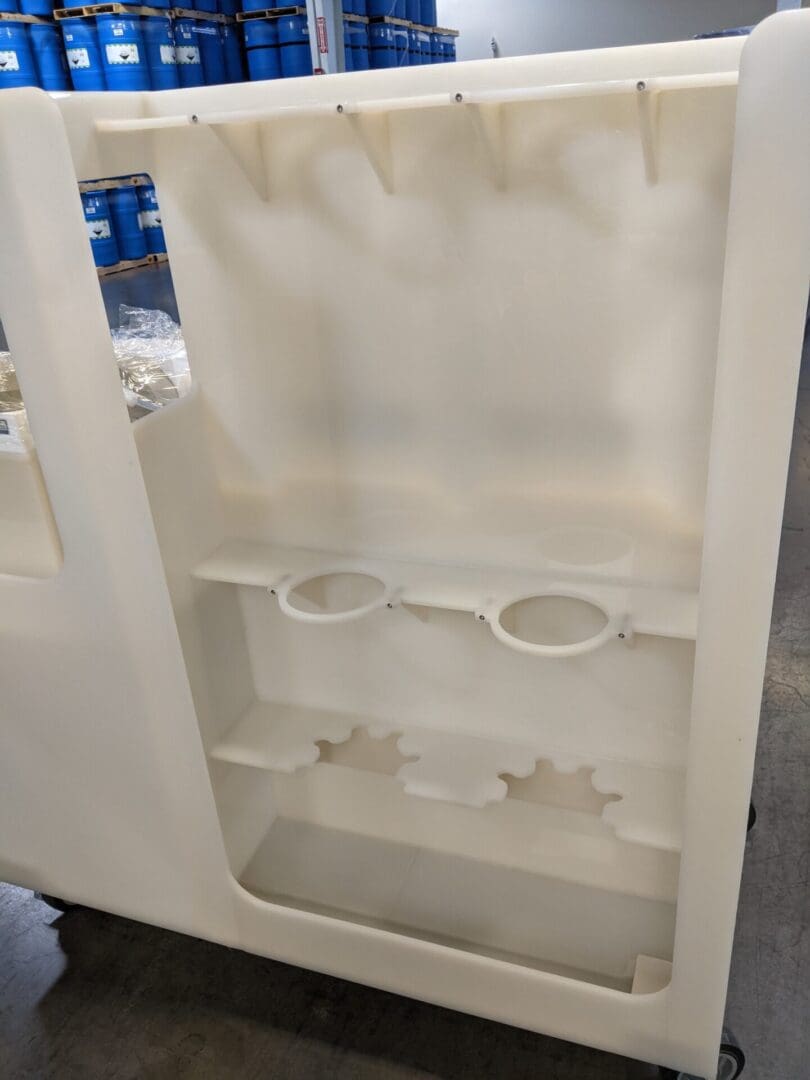 A white refrigerator with two glasses and a cup holder.