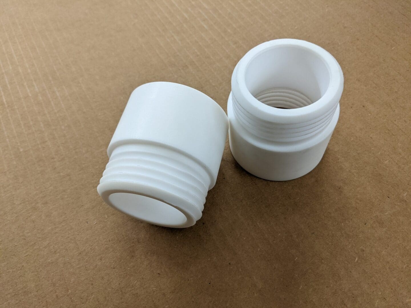 Two white plastic cups sitting on top of a table.