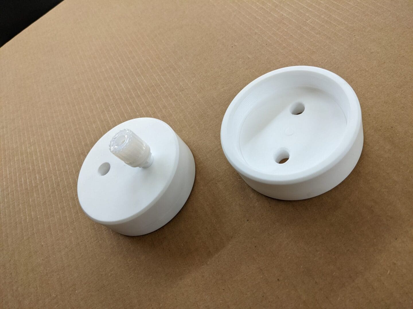 A pair of white knobs on the side of a table.