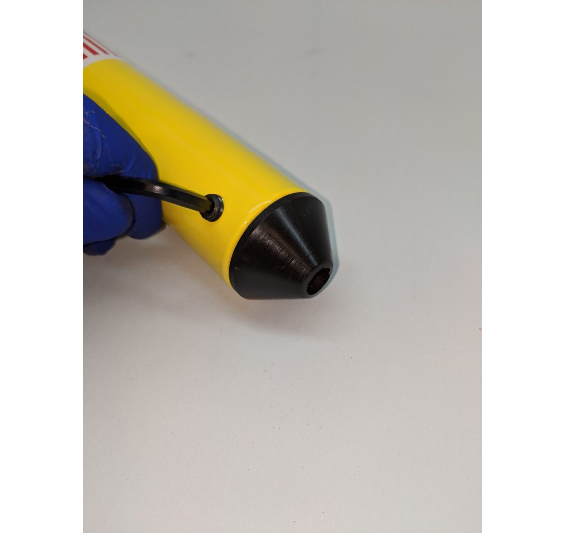 A yellow and black object is being held by a blue tool.
