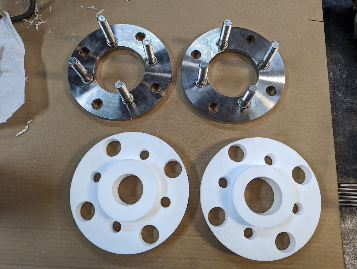 Two white aluminum flanges and one metal one.