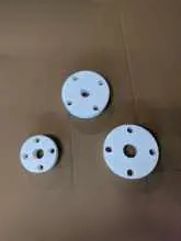 A group of three white plates with holes.