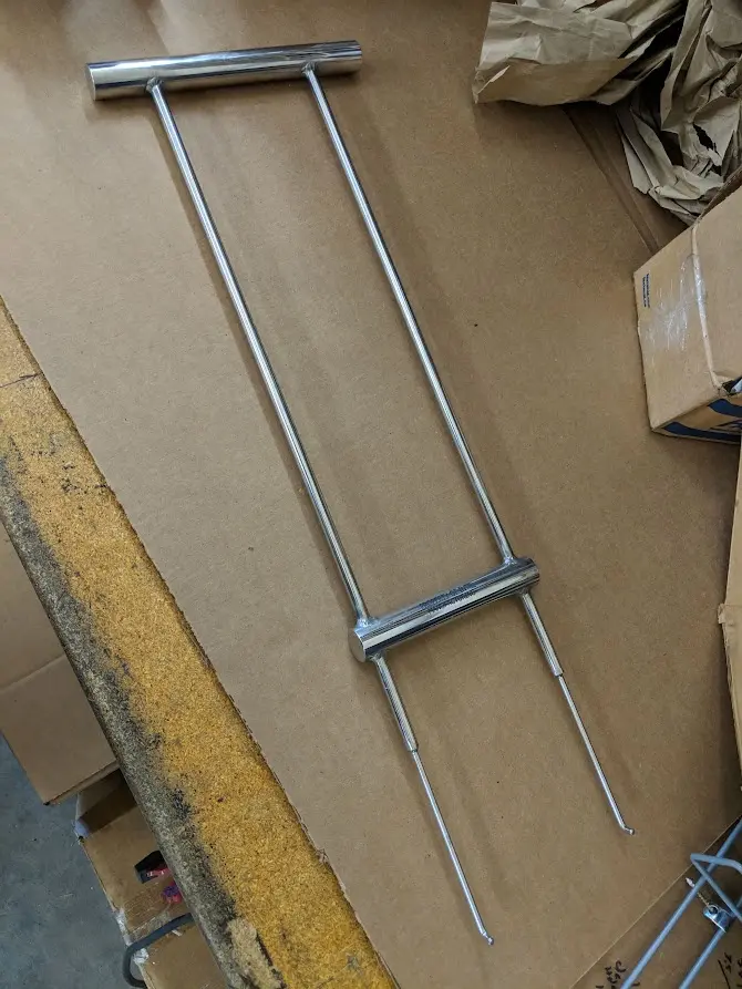 A metal pole with two bars on it.